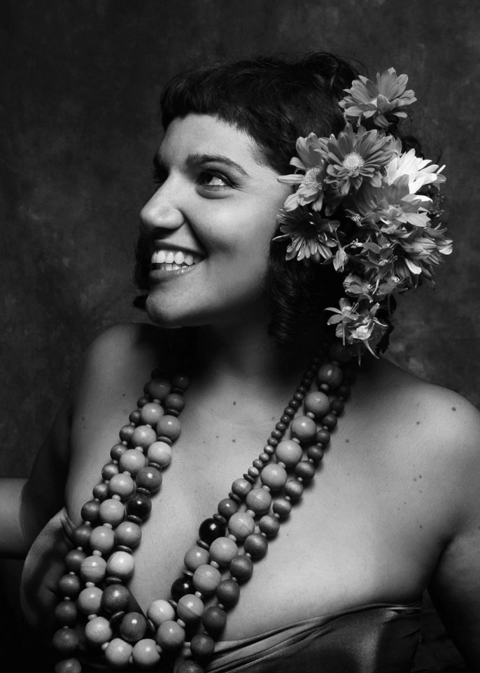 Imagem de Joana Reais a preto e branco com flores na cabeça a sorrir